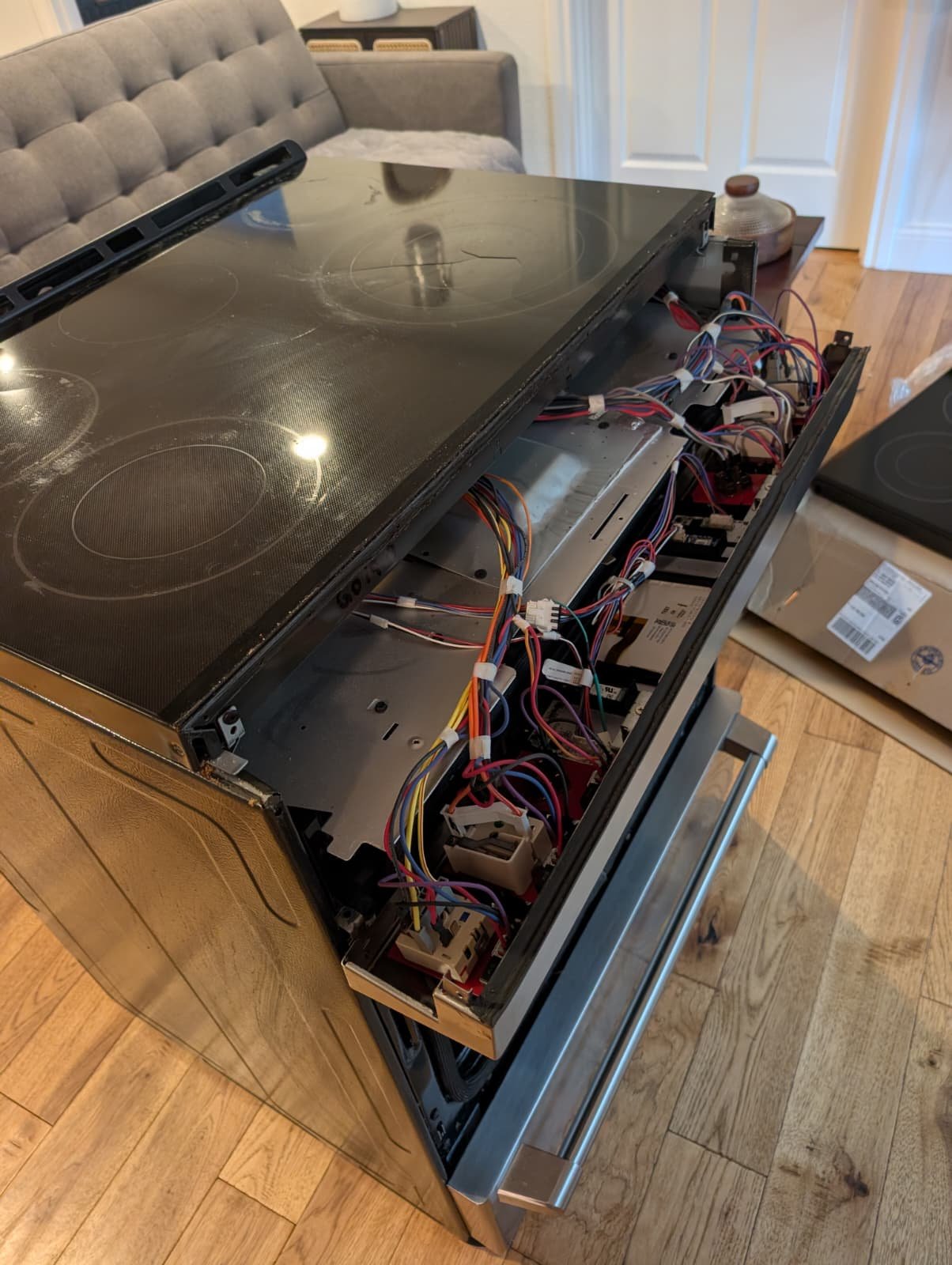 Why You Shouldn’t Cook on a Cracked Glass Stove (And Exactly How We Fix It) 11 Appliance repair technician exposing the complex internal wiring of an electric range