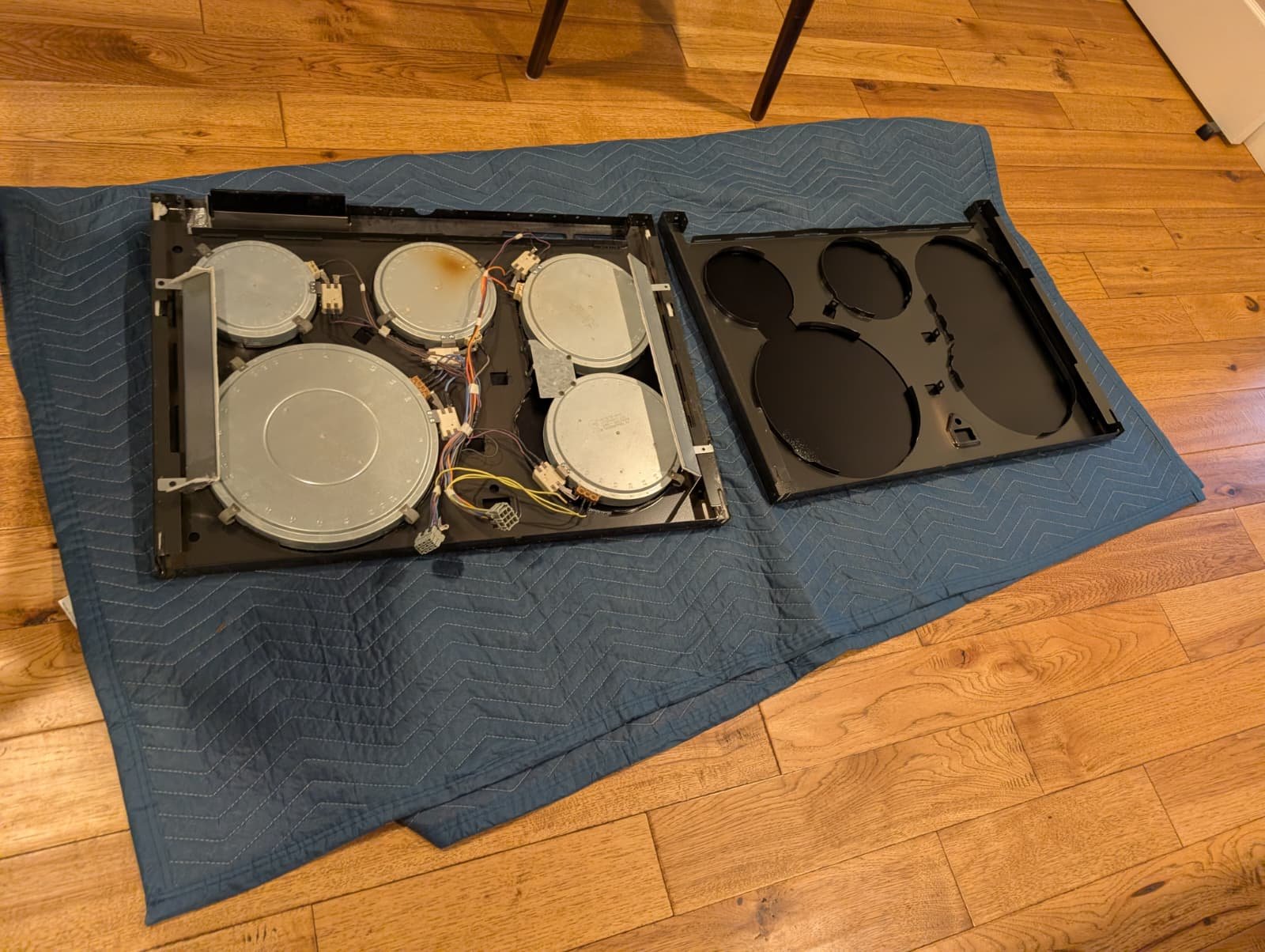 Why You Shouldn’t Cook on a Cracked Glass Stove (And Exactly How We Fix It) 13 Electric stove heating elements transferred to a new glass cooktop frame on a protective blanket.